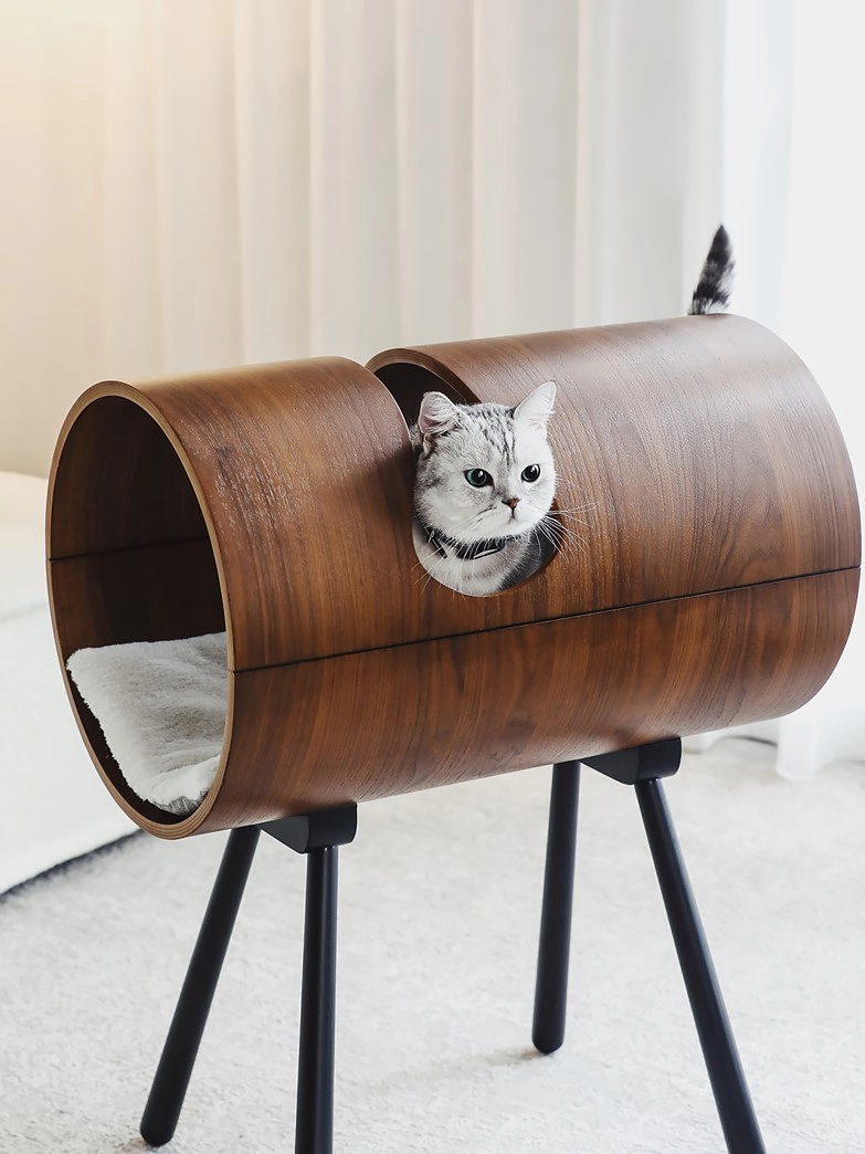 An adorable cat digs into this Nordic-style barrel cat bed.