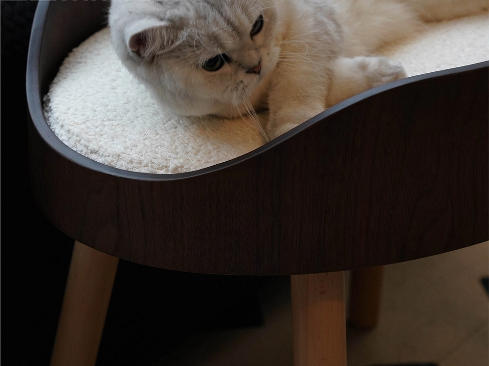 A cat is sleeping on this high solid wood cat bed.